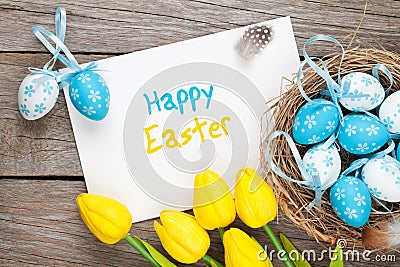 Easter greeting card with blue and white eggs and yellow tulips Stock Photo