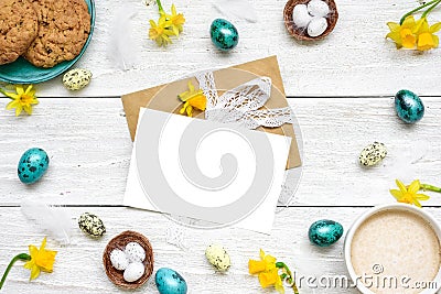 Easter greeting card in frame made of quail eggs, cup of cappuccino, spring flowers and biscuits Stock Photo