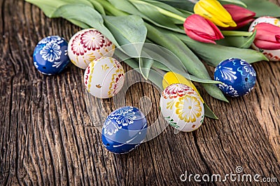 Easter. Hand made easter eggs and spring tulips on old wooden table Stock Photo