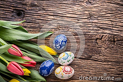 Easter. Hand made easter eggs and spring tulips on old wooden table Stock Photo