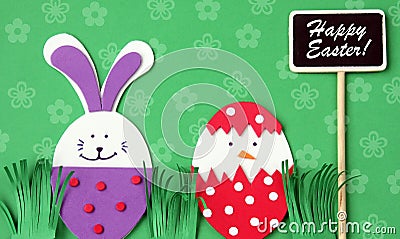 Easter hand made greeting card: festive plastic foam bunny and egg with blackboard isolated on flower background Stock Photo