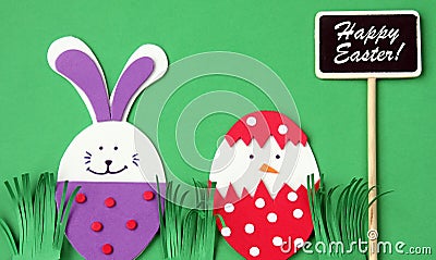 Easter hand made greeting card: festive plastic foam bunny and egg with blackboard isolated on green background Stock Photo