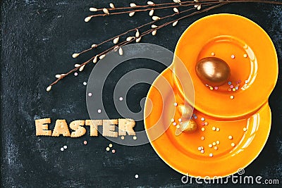 Easter holiday background, orange plate, golden eggs Stock Photo