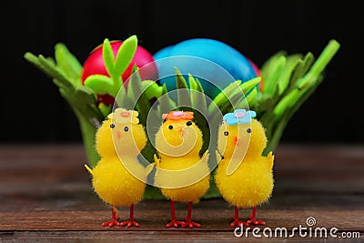 Easter holiday. colored eggs in a basket. three chicks in the foreground Stock Photo