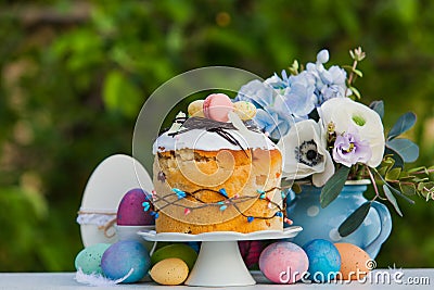 Easter sweet bread, flowers and colorful painted eggs Stock Photo