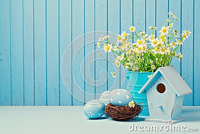 Easter holiday decoration with daisy flowers, eggs and birdhouse Stock Photo