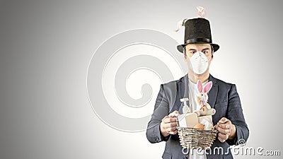 Man in a medical masks dressed as easter bunny with an easter bucket Stock Photo