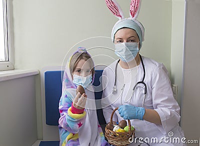 Easter in the hospital: the doctor nurse gives the girl a chocolate egg Stock Photo