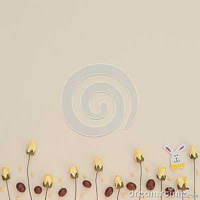 Easter light background with colored brown and yellow chocolate Easter eggs, spring flowers and wooden Easter bunny. Happy Easter Stock Photo
