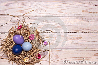 Easter light wooden background with colored eggs in a nest Stock Photo