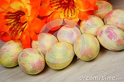 Easter painted eggs on a background of festive flowers. The Easter egg is a ceremonial food and a ritual symbol in Christian Stock Photo