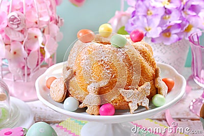 Easter ring cake with candy eggs and cookies on spring table Stock Photo