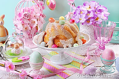 Easter ring cake with candy eggs and cookies on spring table Stock Photo