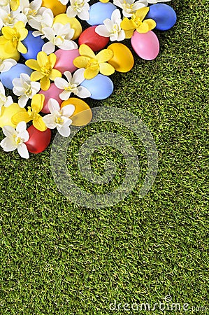 Easter eggs and flowers spring border background, green grass copy space, vertical Stock Photo