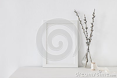 Easter spring still life. Blank vertical picture frame mockup on white wooden table. Blooming pussy willow branches with Stock Photo