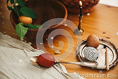 Easter Stylish Rural still life. Stylish Easter egg with modern wax ornaments and natural dyed eggs on rustic wooden table with Stock Photo