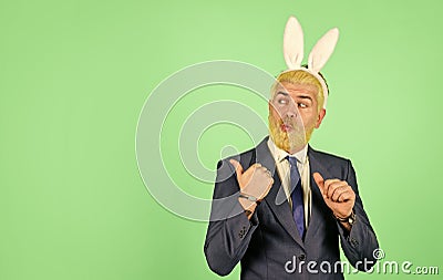 Easter Sunday. Happy businessman advertising product. Bearded man with bunny ears pointing. Presenting product. Product Stock Photo