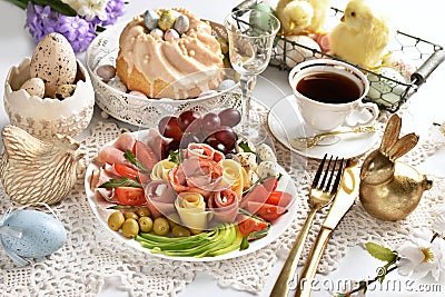 Easter table with a platter of ham and cheese appetizer and ring cake Stock Photo