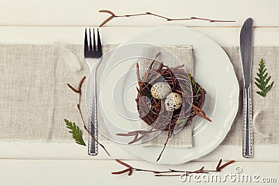 Easter table setting with eggs and spring decoration on rustic background, vintage toning Stock Photo