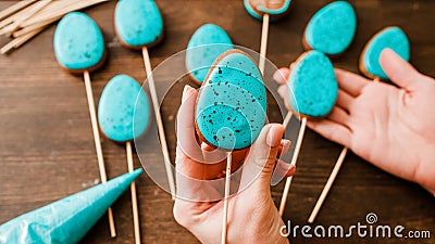 Easter treats woman turquoise icing egg biscuits Stock Photo