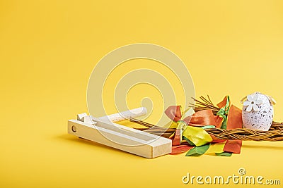 Easter whips, egg and rattle clapper on orange background Stock Photo
