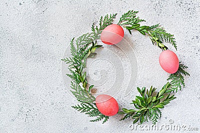 Easter wreath of pine needles, boxwood and painted eggs on light background. Stock Photo