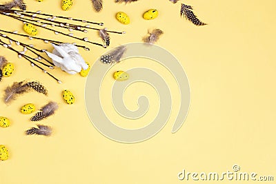 Easter yellow background with decorative bunny, eggs, willow twigs and feathers Stock Photo