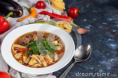 Eastern dish Lagman. Noodles, beef, blue, pepper, tomatoes. Stock Photo