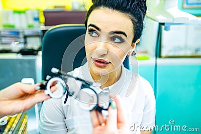 eastern ethnic woman in white medical coat robe selling glasses in optical store Stock Photo