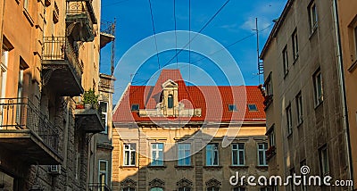 Eastern Europe old city street landmark urban view architecture exterior facade red roof building narrow alley way foreshortening Stock Photo