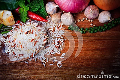 Eastern food spice herb rice garlic chilly pepper mint leaves red onion green pepper on wood table background Stock Photo