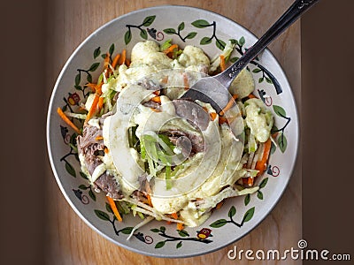 Easy deeth salad of green radish, carrots and turkey in a deep decorative plate, seasoned with a spicy vegetable coax on Stock Photo