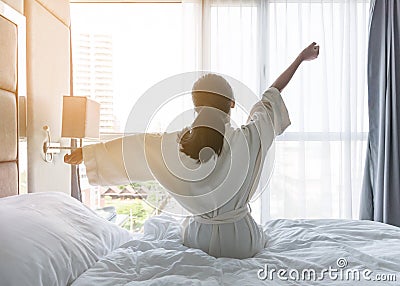 Easy lifestyle young Asian girl waking up in the morning taking a rest relaxing in hotel room for world lazy day Stock Photo