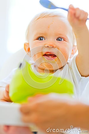 Eat smeared adorable baby playing with spoon Stock Photo