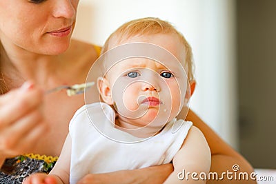 Eat smeared cute little baby feeding by mama Stock Photo