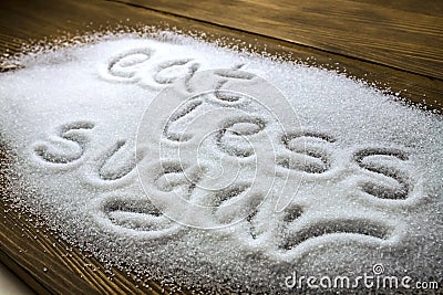 EAT LESS SUGAR written on pile of sugar Stock Photo