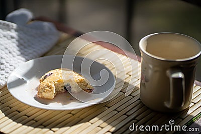 Eating a blueberry scone and cup of hot drink. Stock Photo