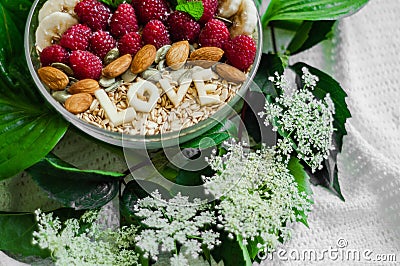 Eating healthy breakfast bowl. The word LOVE in a plate with a healthy meal. Raspberry, Banana, Nuts. Vegetarian food concept Stock Photo