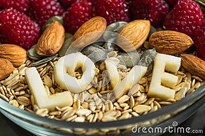 Eating healthy breakfast bowl. The word LOVE in a plate with a healthy meal. Raspberry, Banana, Nuts. Vegetarian food concept Stock Photo