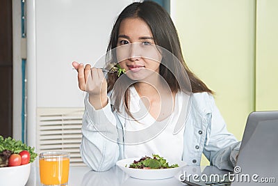 Woman holding dish of salad with variety vegetables and glass of orange juice on the floor. Stock Photo