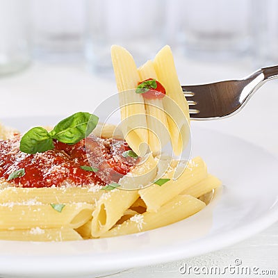 Eating pasta Rigate Napoli with tomato sauce with fork Stock Photo