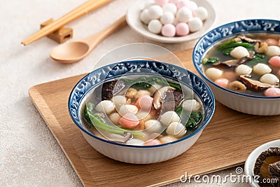 Eating red and white small tangyuan with savory soup and vegetable Stock Photo