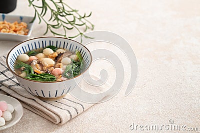 Eating red and white small tangyuan with savory soup and vegetable Stock Photo