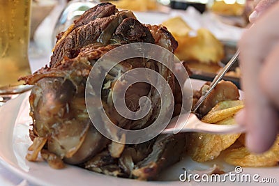 Eating roasted pork knuckle with french fries Stock Photo