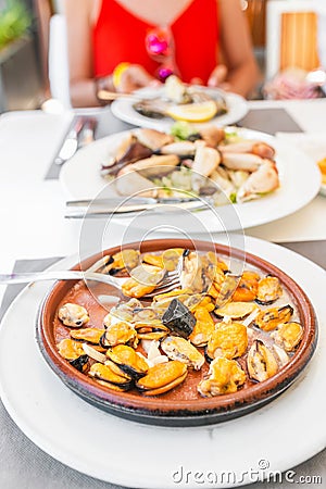 eating shellfish mussels in seafood restaurant Stock Photo