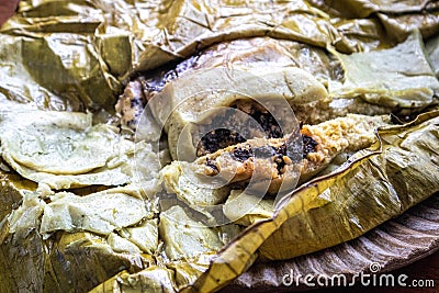 Eating Tamales in Oaxaca, Mexico. The tamale is masa filled with mole negro.. Stock Photo