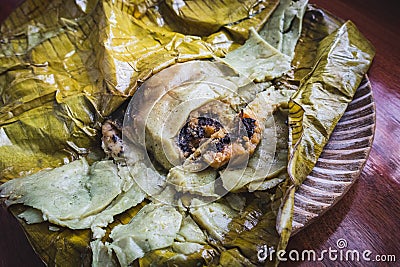 Eating Tamales in Oaxaca, Mexico. The tamale is masa filled with mole negro.. Stock Photo