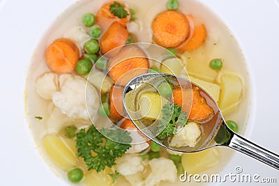 Eating vegetable soup meal with vegetables on spoon from above Stock Photo