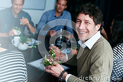 Eating well keeps me focused in the office. Portrait of an office worker eating lunch with coworkers at a boardroom Stock Photo