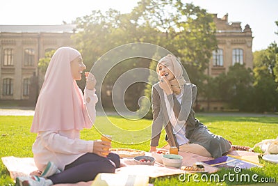 Smiling young muslim student eating yummy berries Stock Photo